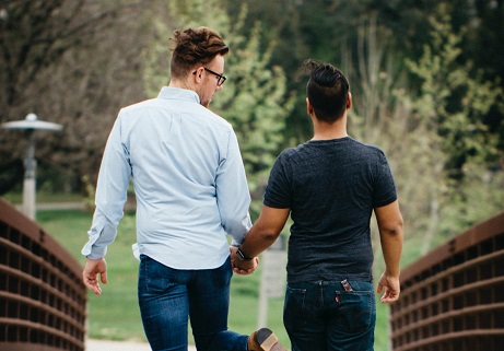happy gay couple holding hands and taking a walk