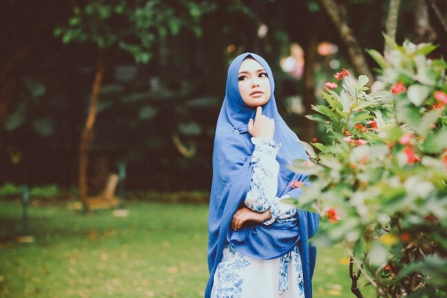 attractive muslim girl standing in a garden