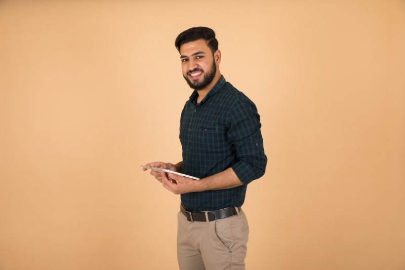 attractive muslim man holds his tablet