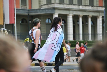 two people with a transgender flag at a pride parade