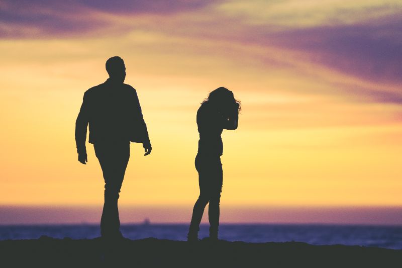 man walking towards woman in the sunset